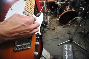 young music player and band friends have training in home garage